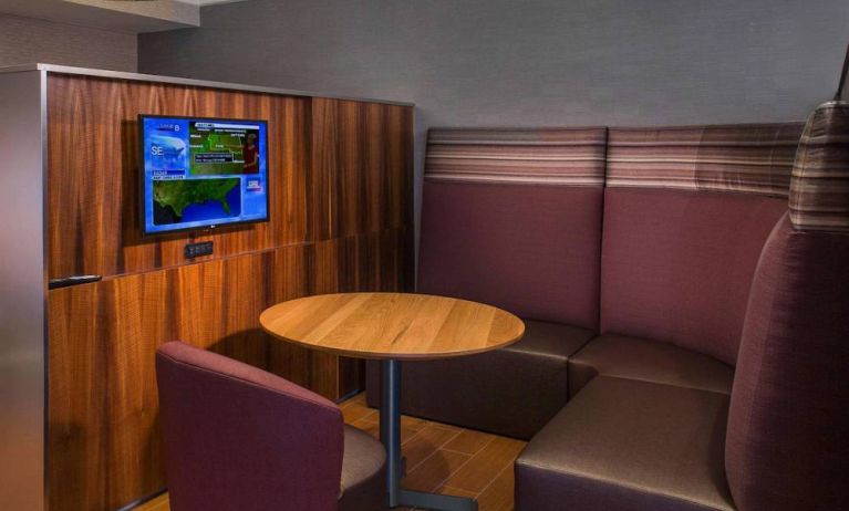 A media pod, featuring coffee table, TV, and comfortable seating where guests can relax and co-work.