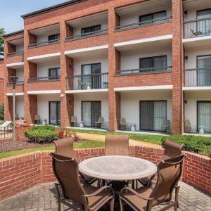 The hotel patio is close to the rooms, and has a circular table surrounded by a quintet of chairs.