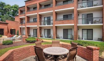 The hotel patio is close to the rooms, and has a circular table surrounded by a quintet of chairs.