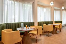 The hotel’s breakfast area has comfy seating, stylish tables, and large windows.