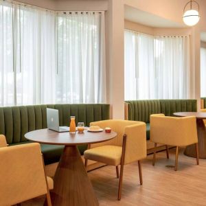 The hotel’s breakfast area has comfy seating, stylish tables, and large windows.