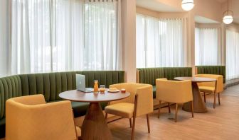 The hotel’s breakfast area has comfy seating, stylish tables, and large windows.