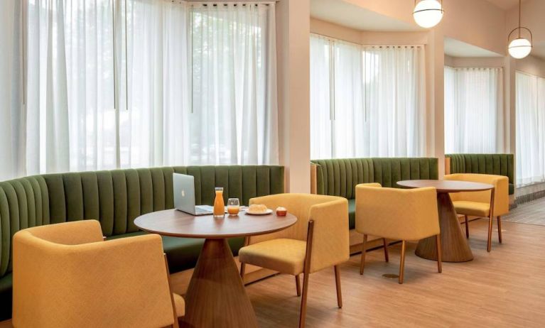 The hotel’s breakfast area has comfy seating, stylish tables, and large windows.