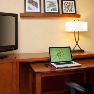 Sonesta Select Boston Danvers guest room workspace, including desk, chair, lamp, and TV.