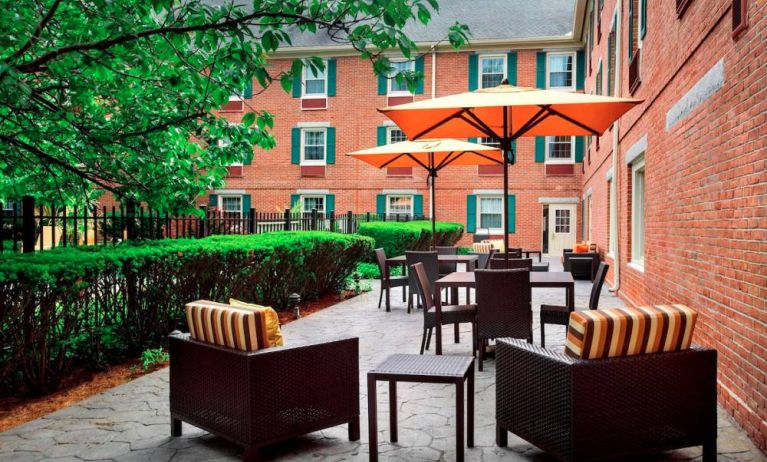 The hotel’s patio has armchairs and coffee tables, plus shaded tables and chairs.