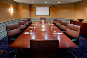 Sonesta Select Boston Danvers meeting room, with ten swivel chairs around a long table, and a projector screen.