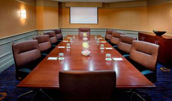 Sonesta Select Boston Danvers meeting room, with ten swivel chairs around a long table, and a projector screen.