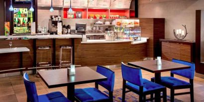 Breakfast area in Sonesta Select Boston Danvers, with seating at small tables or tall bar stools, and a range of healthy options.