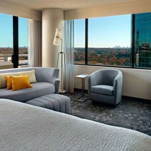 Sonesta Select Atlanta Cumberland Galleria double bed guest room, featuring sofa, chair, windows, and TV.