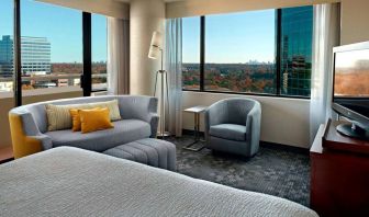 Sonesta Select Atlanta Cumberland Galleria double bed guest room, featuring sofa, chair, windows, and TV.