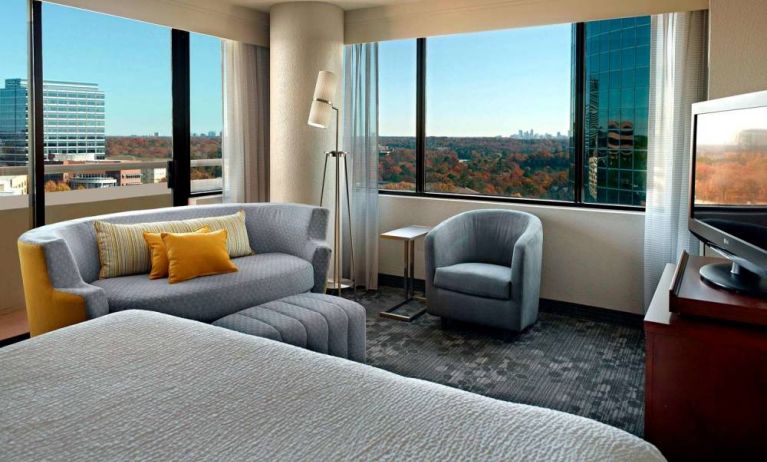 Sonesta Select Atlanta Cumberland Galleria double bed guest room, featuring sofa, chair, windows, and TV.