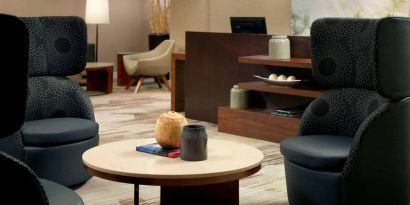 Sonesta Select Atlanta Cumberland Galleria’s lobby lounge is furnished with comfortable chairs and coffee tables.