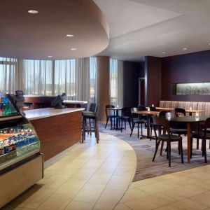 Sonesta Select Atlanta Cumberland Galleria’s dining area features a bar, both tall stool and table seating, and large windows.