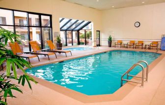 Sonesta Select Seattle Bellevue Redmond’s indoor pool has an adjacent hot tub and nearby loungers and chairs.