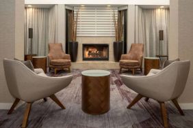 Sonesta Select Seattle Bellevue Redmond’s lobby includes coffee tables and comfy chairs close to a fireplace.