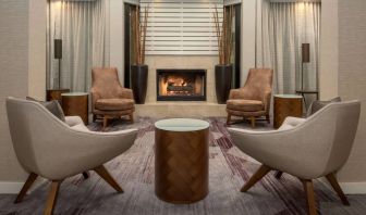 Sonesta Select Seattle Bellevue Redmond’s lobby includes coffee tables and comfy chairs close to a fireplace.