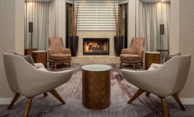 Sonesta Select Seattle Bellevue Redmond’s lobby includes coffee tables and comfy chairs close to a fireplace.