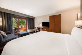 Double bed guest room in Sonesta Select San Jose Airport, with workspace desk and chair, plus TV.