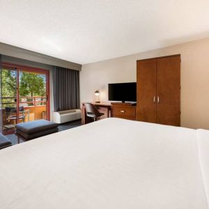 Double bed guest room in Sonesta Select San Jose Airport, with workspace desk and chair, plus TV.