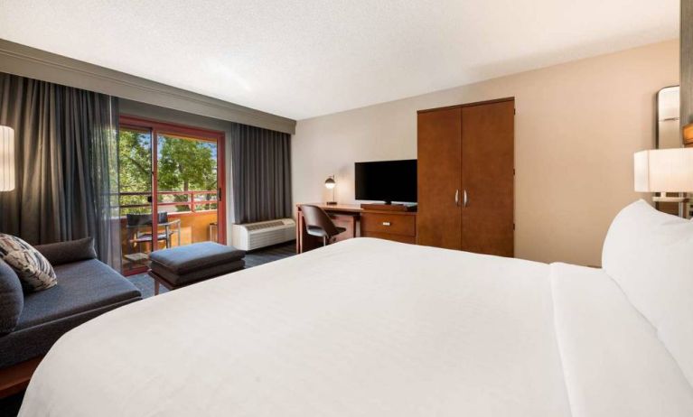 Double bed guest room in Sonesta Select San Jose Airport, with workspace desk and chair, plus TV.