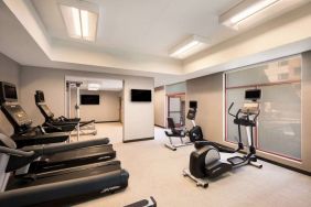 Sonesta Select San Jose Airport’s fitness center is equipped with a range of exercise machines and a wall-mounted TV.