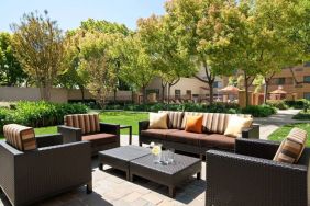 The hotel’s patio has trees nearby, and a mix of sofa and armchair seating.