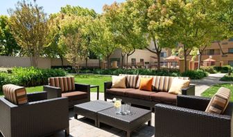 The hotel’s patio has trees nearby, and a mix of sofa and armchair seating.