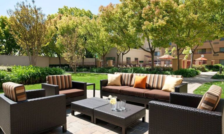 The hotel’s patio has trees nearby, and a mix of sofa and armchair seating.