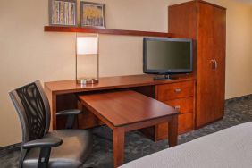 Guest room workspace in Sonesta Select Charlotte University Research Park, including desk, chair, and television.