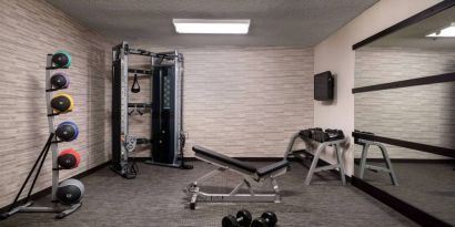 Sonesta Select Charlotte University Research Park’s fitness center is equipped with free weights, a bench, wall-mounted TV, and gym balls.