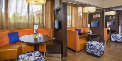 The hotel’s meeting pods provide comfortable seating with televisions and coffee tables for guests to socialize and work.