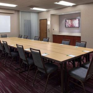 Meeting room in Sonesta Select Boston Milford, furnished with seating for 16 attendees, a long table, and a whiteboard.