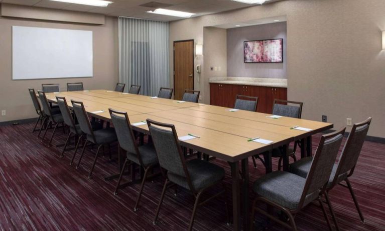 Meeting room in Sonesta Select Boston Milford, furnished with seating for 16 attendees, a long table, and a whiteboard.