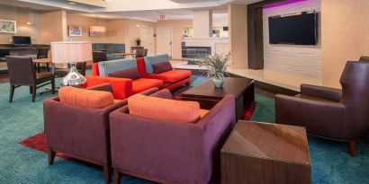 The hotel’s lobby lounge features comfortable chairs facing a widescreen, wall-mounted TV, with coffee tables close at hand.