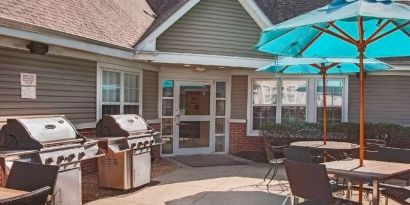 The hotel’s patio area includes shaded tables and chairs, as well as multiple barbecues.