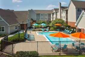 Sonesta ES Suites Baltimore BWI Airport’s outdoor pool is ringed by a fence, within which there are sun loungers, plus shaded tables and chairs.