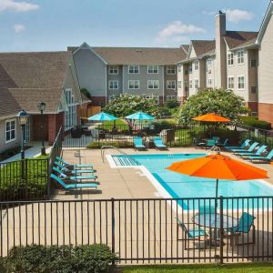 Sonesta ES Suites Baltimore BWI Airport’s outdoor pool is ringed by a fence, within which there are sun loungers, plus shaded tables and chairs.