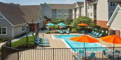 Sonesta ES Suites Baltimore BWI Airport’s outdoor pool is ringed by a fence, within which there are sun loungers, plus shaded tables and chairs.