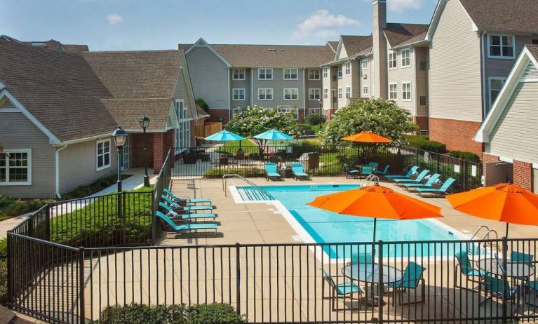 Sonesta ES Suites Baltimore BWI Airport’s outdoor pool is ringed by a fence, within which there are sun loungers, plus shaded tables and chairs.