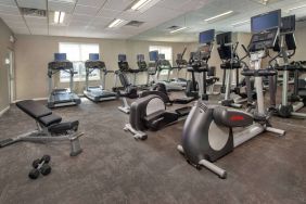 The fitness center in Sonesta ES Suites Baltimore BWI Airport is equipped with free weights and a bench alongside an assortment of exercise machines.