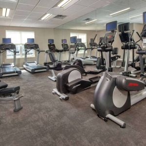 The fitness center in Sonesta ES Suites Baltimore BWI Airport is equipped with free weights and a bench alongside an assortment of exercise machines.