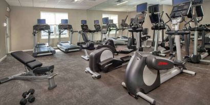 The fitness center in Sonesta ES Suites Baltimore BWI Airport is equipped with free weights and a bench alongside an assortment of exercise machines.