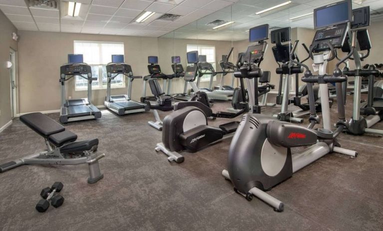 The fitness center in Sonesta ES Suites Baltimore BWI Airport is equipped with free weights and a bench alongside an assortment of exercise machines.