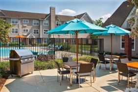 The hotel’s patio has shaded tables and chairs next to a barbecue, with the swimming pool only steps away.