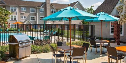 The hotel’s patio has shaded tables and chairs next to a barbecue, with the swimming pool only steps away.