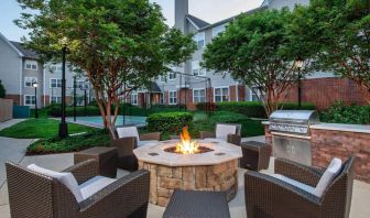 Sonesta ES Suites Baltimore BWI Airport’s fire pit is surrounded by armchairs and coffee tables, with a barbecue conveniently close.