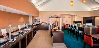 The breakfast area in Sonesta ES Suites Allentown Bethlehem Airport has a mix of table and tall stool seating, and a range of healthy eating options.