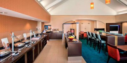 The breakfast area in Sonesta ES Suites Allentown Bethlehem Airport has a mix of table and tall stool seating, and a range of healthy eating options.