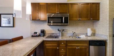 Sonesta ES Suites Chicago Downtown Magnificent Mile - Medical guest room kitchen, equipped with microwave, sink, and breakfast bar.