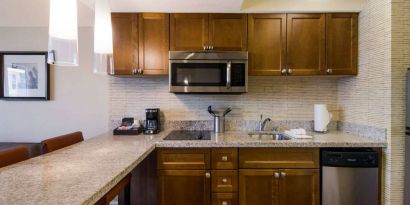 Sonesta ES Suites Chicago Downtown Magnificent Mile - Medical guest room kitchen, equipped with microwave, sink, and breakfast bar.